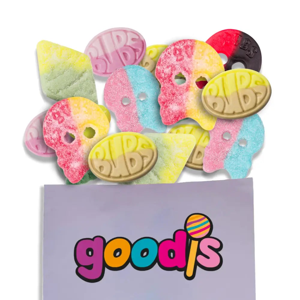 A mix of Swedish candy from the brand "Bubs", including skulls, ovals and rhombs in different colors and shapes, falling out from a purple candy bag with "Goodis" in the front.
