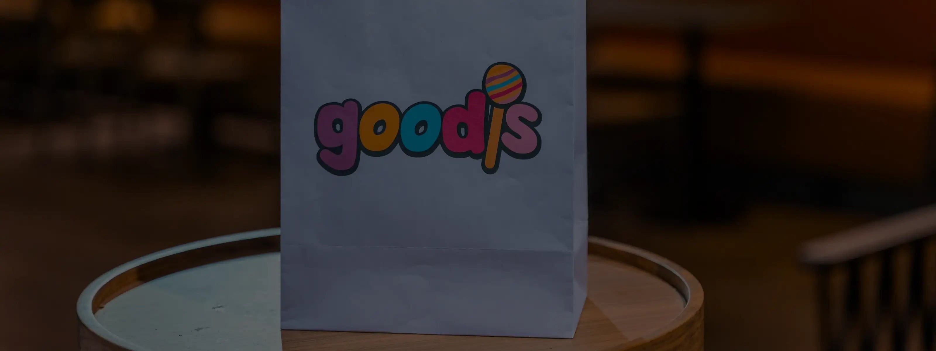 A purple bag of Swedish candy standing on a round table.