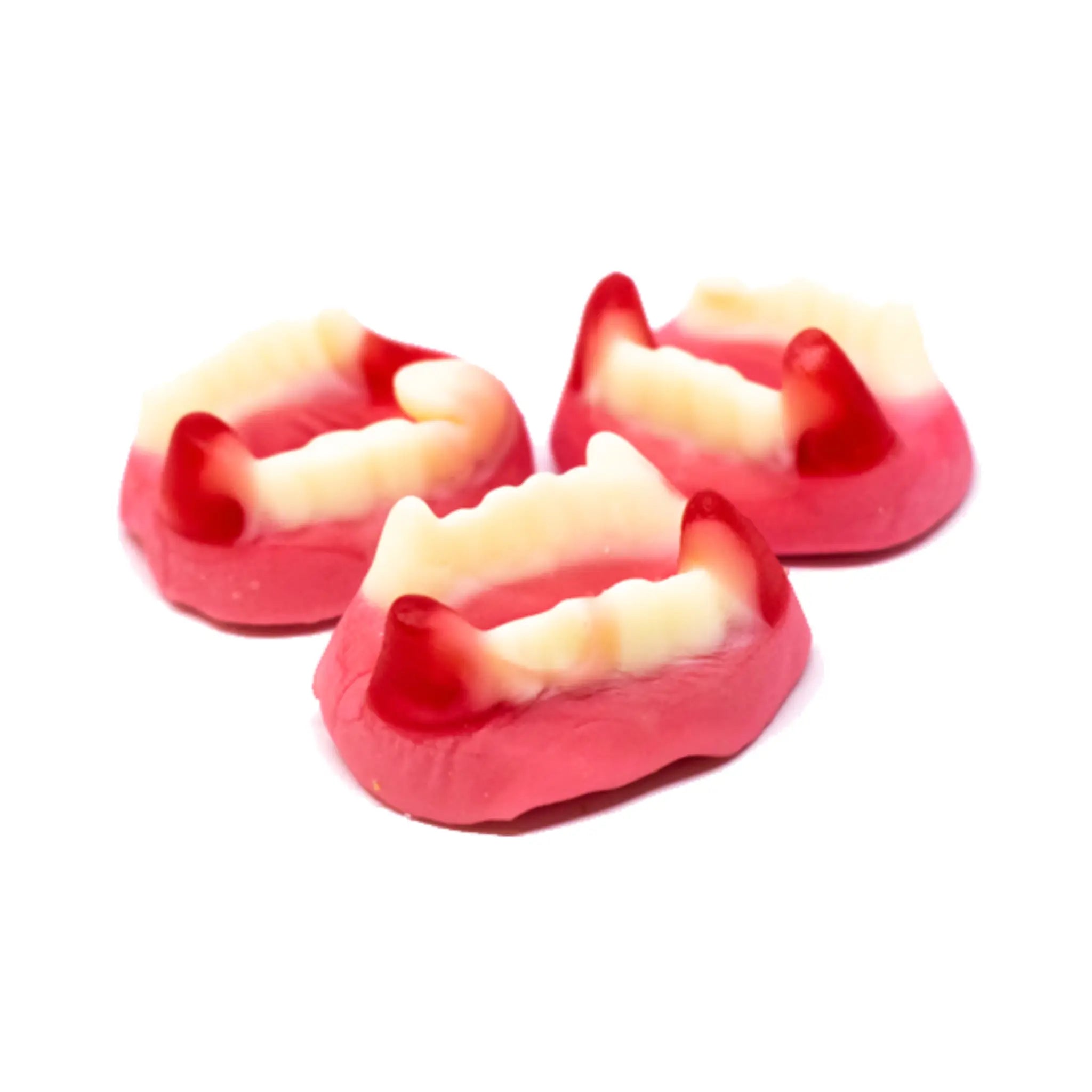 Three pieces of Swedish candy shaped like white teeth, with a touch of red and a pink bottom.