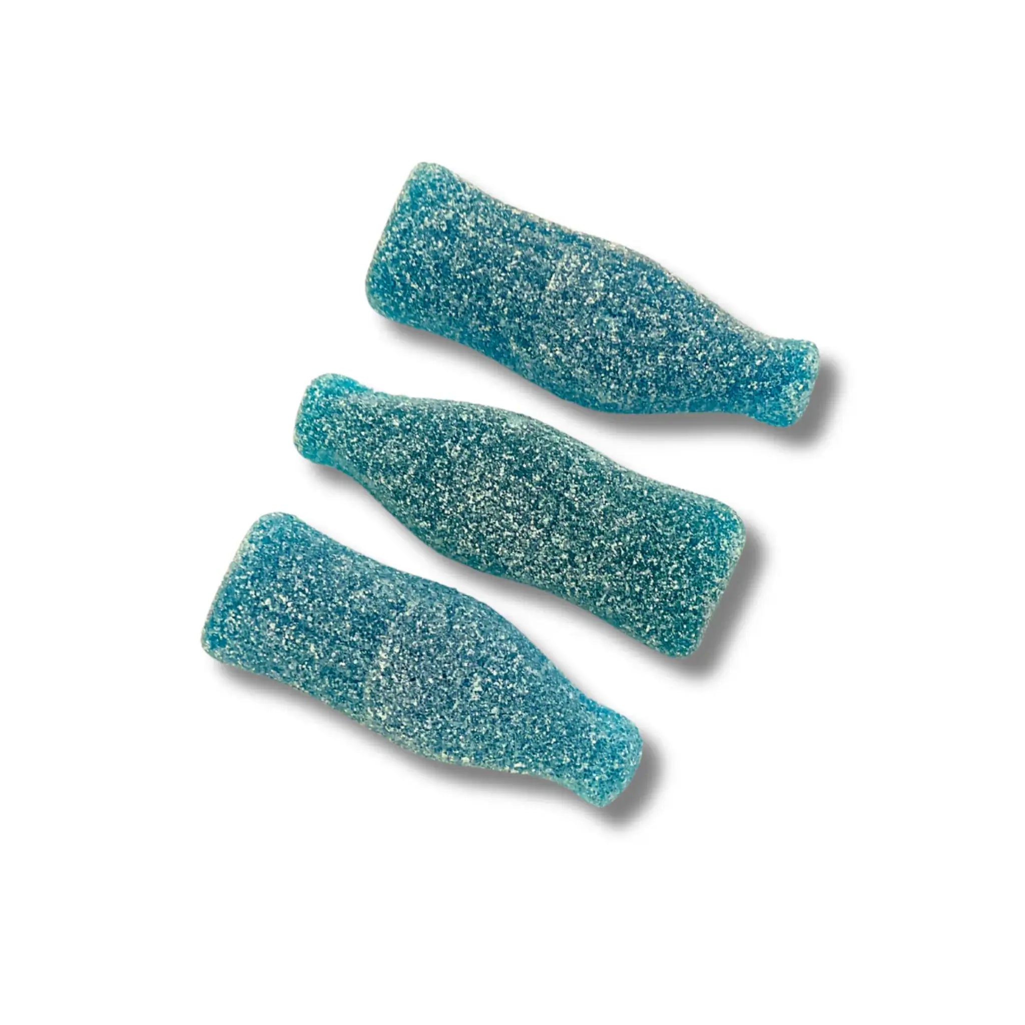 Three pieces of Swedish candy in the shape of blue bottles, coated in sugar.