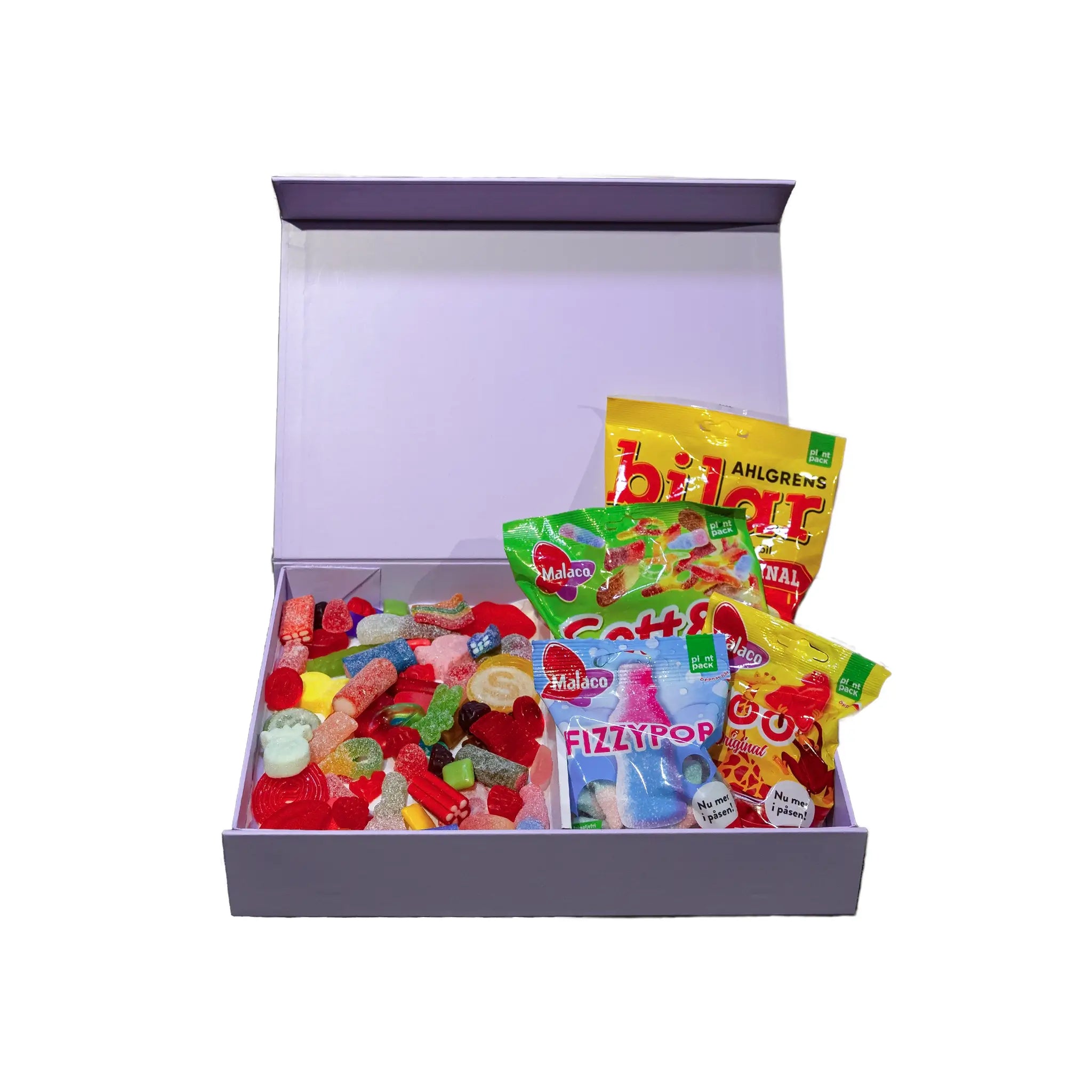An open purple gift box containing different kinds of candy, both in bags and in pieces.