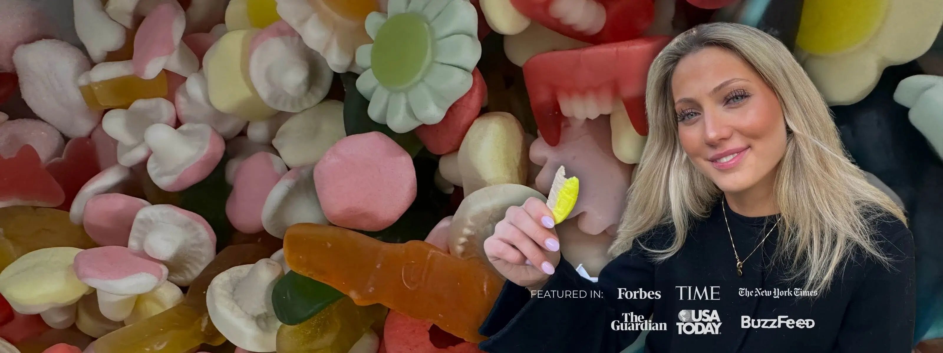 A blonde girl holding a piece of yellow and brown Swedish candy, against a background of mixed candy.