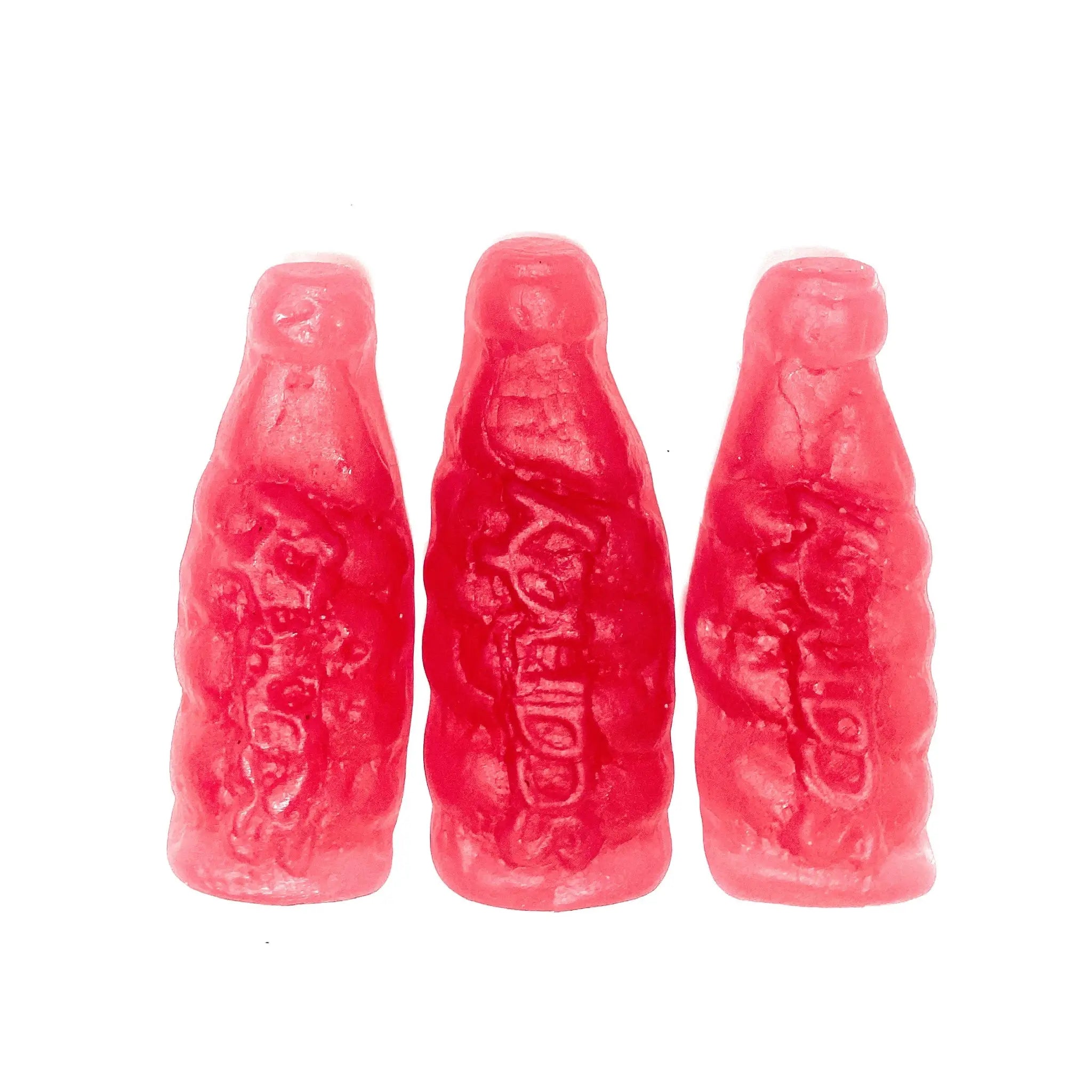 Three pieces of Swedish candy in the shape of bottles in red.