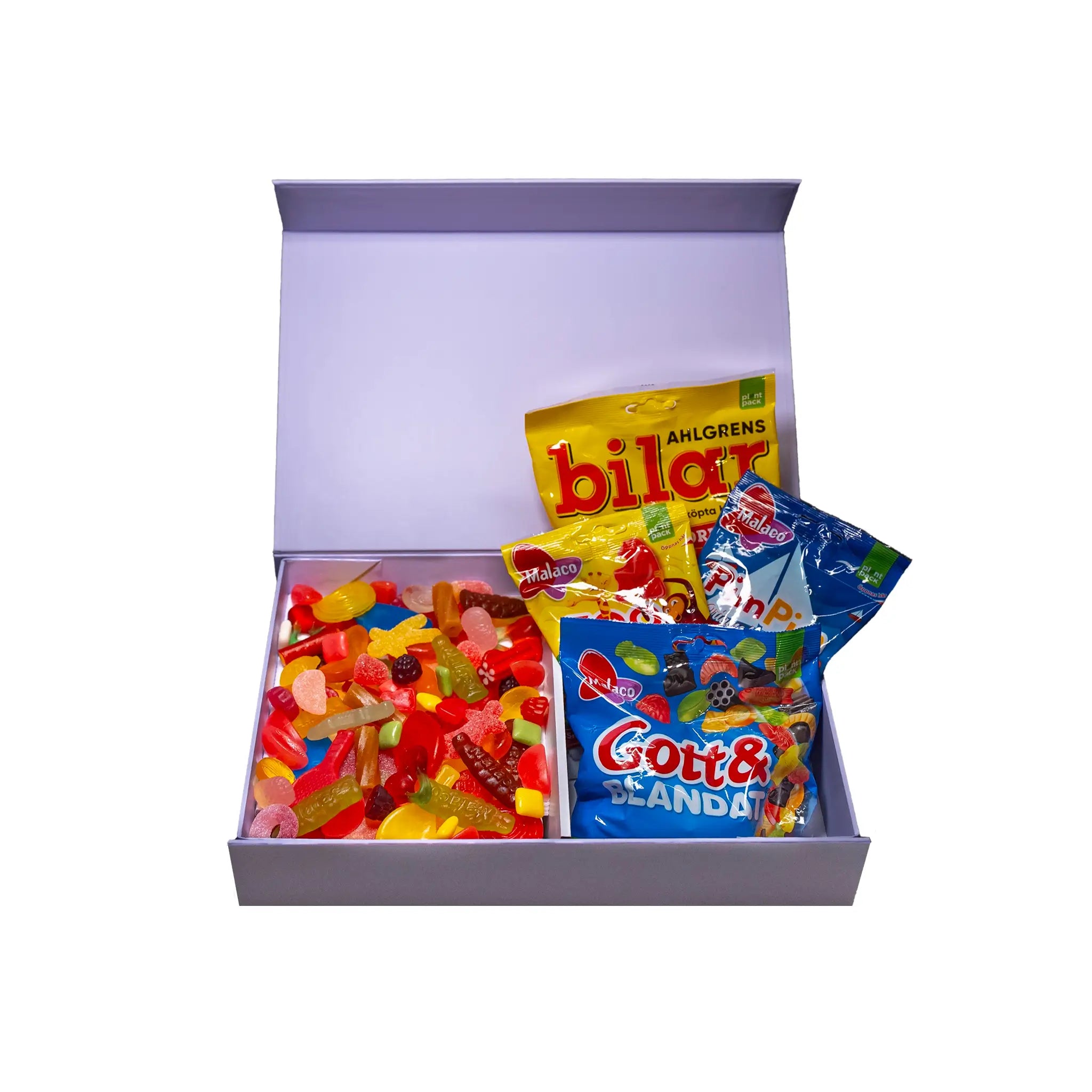 An open purple gift box with candy in different shapes and colors, both bags and pieces.