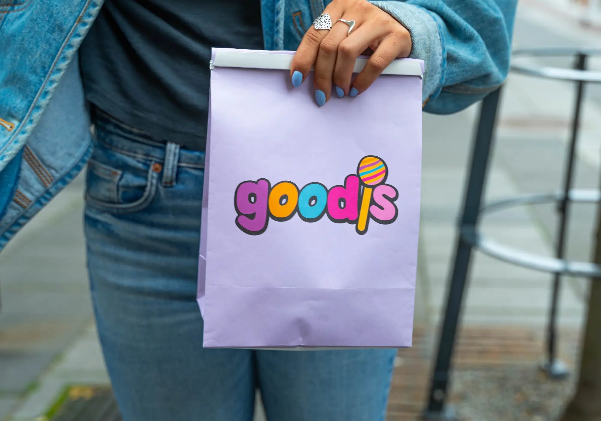 Woman in jeans holding candy bag.