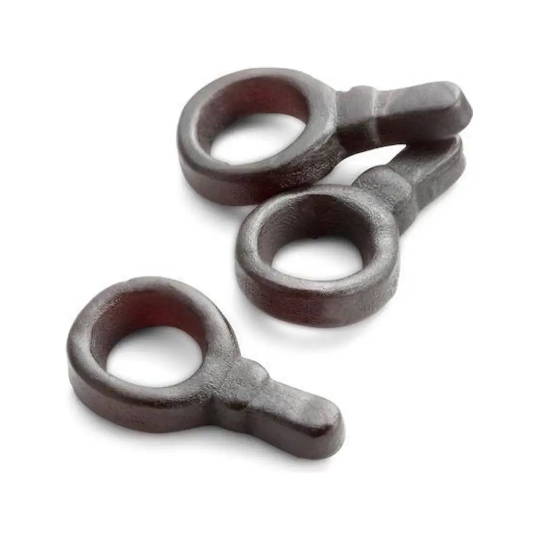 Three pieces of candy in the shape of pacifiers, in black color.