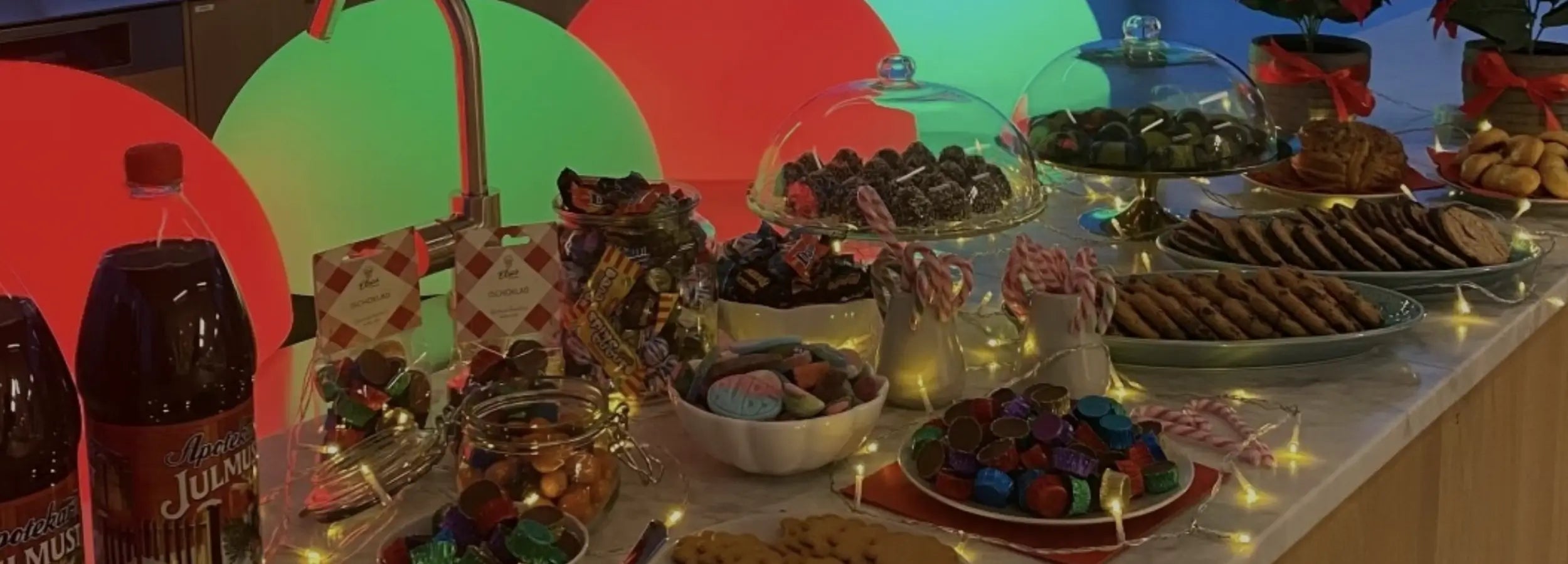 Different kinds of Swedish candy, cookies, chocolate and drink in an office.